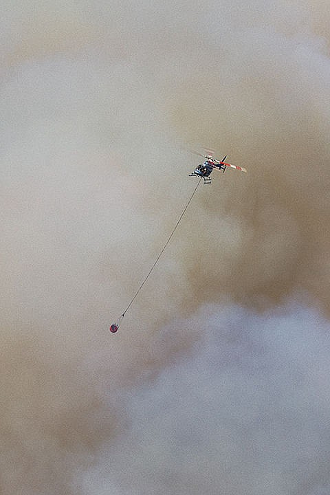 &lt;p&gt;A helicopter emerges from a huge plume of smoke after dousing a wildland fire with water. The aircraft made dozens of passes in an effort to extinguish the blaze.&lt;/p&gt;
