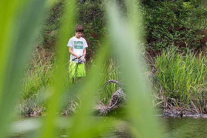 &lt;p&gt;Justice Leonard (11) fishes on the banks of the Spokane River on Blackwell Island Tuesday afternoon.&lt;/p&gt;