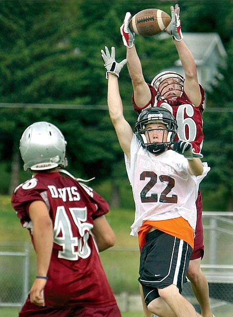 Flathead's Jareth Wilson (22) leaps up for the pass as Helena High's Willy O'Brien gets the interception during Flathead's noon game against one of the two Helena High teams Saturday at the Flathead Brave 7-on-7 Passing Tournament at Legends Stadium. At right is Helena's Derek Davis. Flathead lost that game, 26-0, but went on to win the next two games. Karen Nichols/Daily Inter Lake