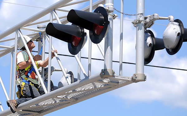 Colin House of Kalispell works on maintaining the lights at the railroad crossing on Highway 2 on Wednesday in Columbia Falls.