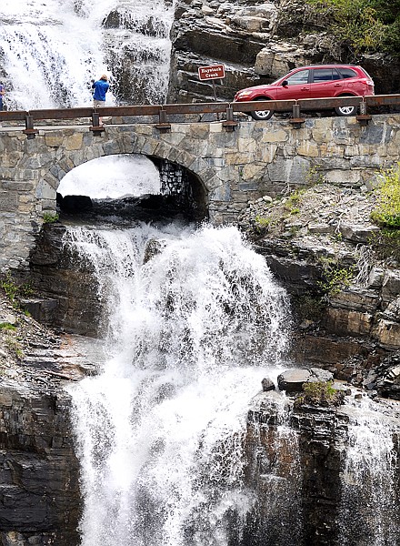 Charles Stirum of Granite, Colo., takes photos of Haystack Creek as it crosses under Going-to-the-Sun Road in Glacier National Park.