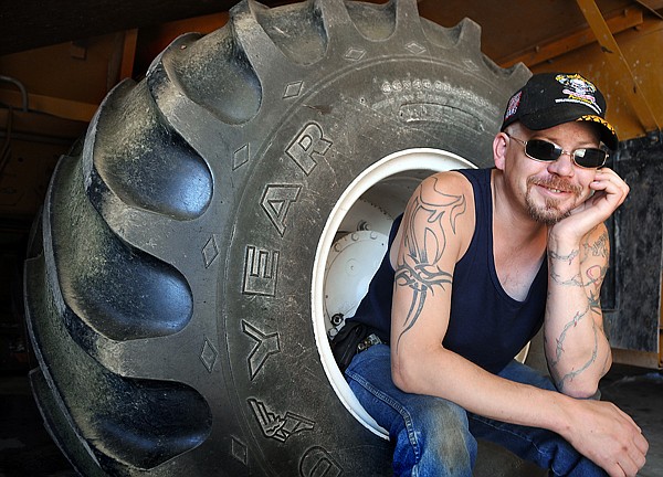 Rich Gordon of Kalispell poses with a Goodyear 66x43x25 tire, the same kind he uses with his truck, on Wednesday in Kalispell.