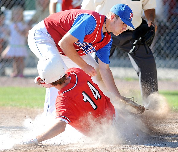 Kalispell Lakers Marshall Boyland (14) slides safely home before Apple Valley Packers pitcher Reed Jaspers can tag him out during Thursday&#146;s game in Whitefish at the 26th annual Sapa-Johnsrud Memorial Tournament. Boyland&#146;s run put Kalispell on top 6-3.