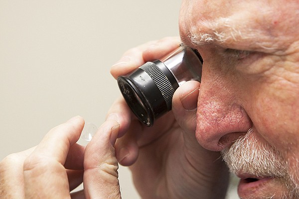 &lt;p&gt;Steve Dunn inspects a contact lens created in his lab
Thursday.&lt;/p&gt;