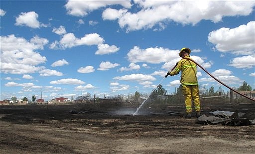 &lt;p&gt;A volunteer firefighter sprays down a hotspot after a small wildfire Tuesday, June 19, 2012, near Mountain Home, Idaho. The blaze, ignited Monday night and fanned by strong winds, destroyed six homes on the city's south edge. (AP Photo/Todd Dvorak)&lt;/p&gt;