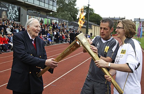 &lt;p&gt;LEFTERIS PITARAKIS/Associated Press The Olympic Flame is passed between Sir Roger Bannister and Oxford doctoral student Nicola Byrom on the running track at Iffley Road Stadium in Oxford, England, on Tuesday. Bannister was the first person ever to run a sub four-minute-mile, on May 6, 1954, at this track in Oxford. Bannister returned to the site of his greatest sporting achievement, to participate in the Olympic Torch relay as the Olympic flame is carried around the country to the opening ceremony of the 2012 London Olympic Games.&lt;/p&gt;