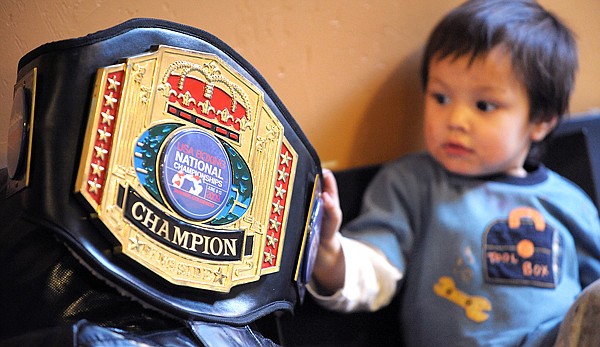 Duran Caferro's son, Duran, plays with his father's Championship belt on Saturday at Straight Blast Gym in Kalispell.