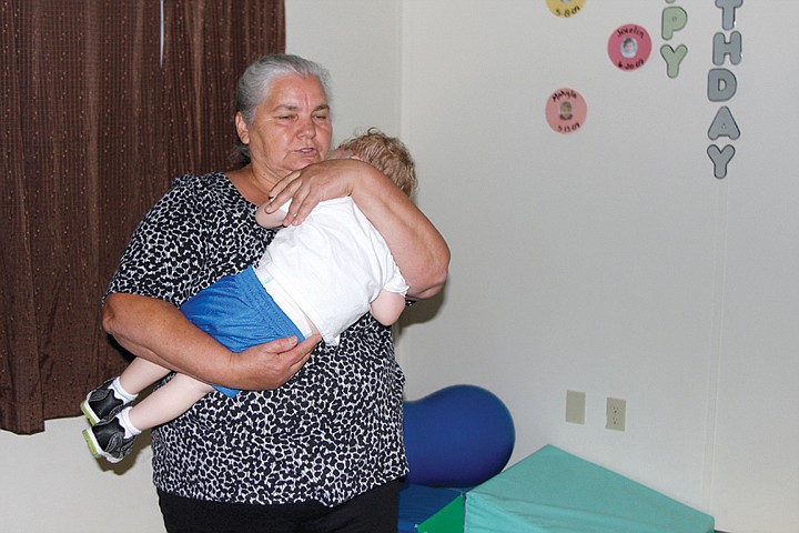 Mariya Radchishina, of Big Bend Community College's Learning
Center, comforts a boy who awoke during naptime. She came to the
U.S. from the Ukraine almost 11 years ago for better opportunities
and religious freedoms.