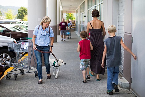 &lt;p&gt;Cindy Elliot, with Guide Dogs for the Blind School, walks 12-week old Theo Thursday while training him in socialization at a department store in Coeur d'Alene.&lt;/p&gt;