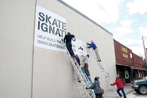 From left, Ben Ferencz and Jim Thornton, on ladders, set up the sign with Doug Martin and Bruce Nerby (below right).