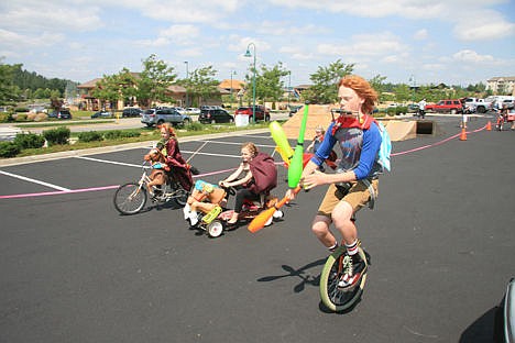 &lt;p&gt;Mickey Howard, 14, concentrates as he plays harmonica, juggles and rides his unicycle Sunday at Coeur d&#146;Alene&#146;s inaugural Kinetic Fest. His little sisters Hazel, 9, left, and Lydia, 12, ride alongside him as the youngest, Sally, 6, follows with a wheelbarrow.&lt;/p&gt;