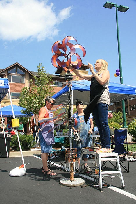 &lt;p&gt;Deborah Loy uses a stepladder to reach creative heights Sunday as she and Daris Judd, center, and Karlene Schoedel work on an original kinetic sculpture.&lt;/p&gt;