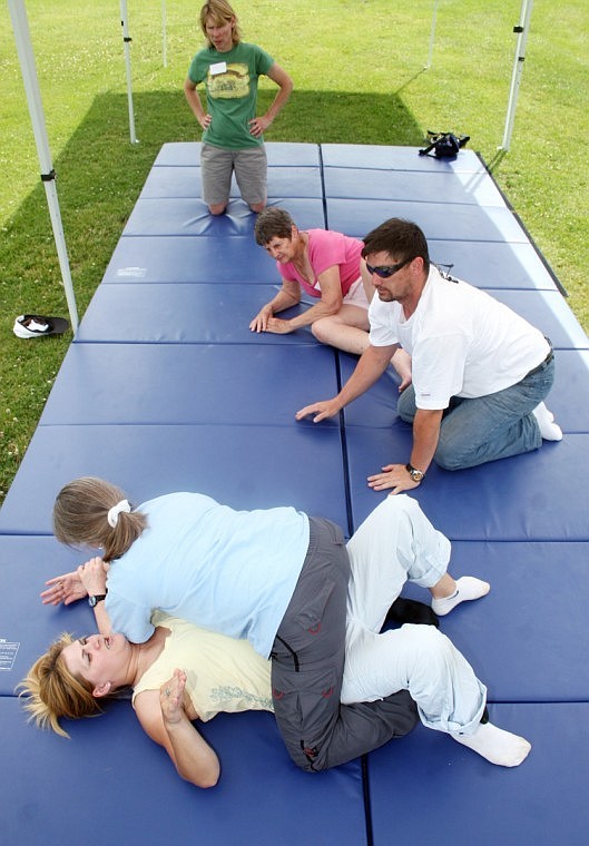 During a self defense class, instructor Misty Miller (bottom) gets pinned by Heidi Mack of Plains. Looking on is Jesse Miller of Thompson Falls, Virginia Fortner, of Plains (pink shirt) and Roni Mitch, from Plains (green shirt). The Millers taught some basic moves learned from jijitsu.