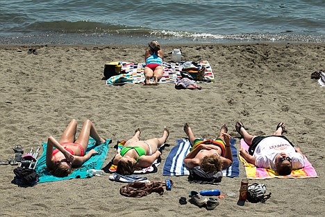<p>Sunbathers soak up some rays at City Beach in Coeur d'Alene Tuesday afternoon when temperatures soared upward of 100 degrees in some areas.</p>