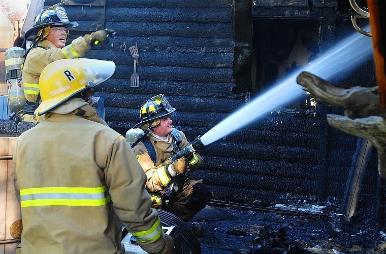 Whitefish firefighter Matt Avelar hoses down the back portion of the building that serves as a day care for dogs. Fire crews were dispatched at 3:29 p.m. after a plume of black smoke coming from the building was seen from U.S. 93. No one was injured.