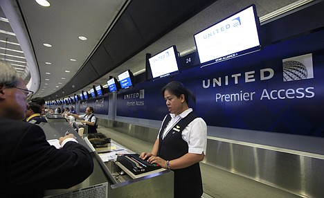 &lt;p&gt;Ticket agent Dee Manzon helps a customer at United Airlines premier access check-in counter at San Francisco International Airport in San Francisco, Wednesday.&lt;/p&gt;