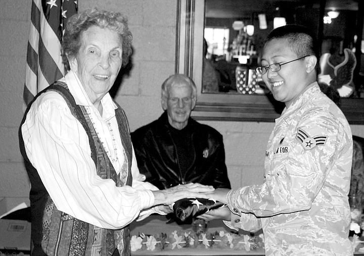 An unidentified airman presents the folded flag, which has flown
on combat missions in both Iraq and Afghanistan, to Enid Clay.