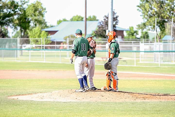 Hunter Boyd (11), Anthony Longmire (2), and Nathan Ball (24) talk strategy and pitch location in the top of the second ining.