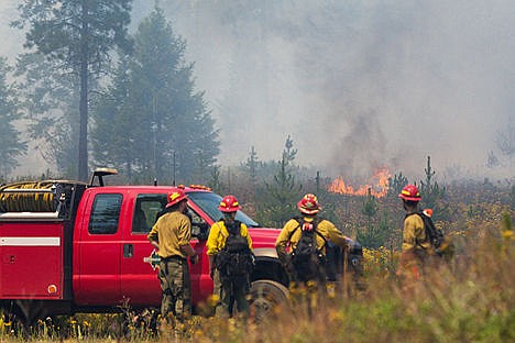 &lt;p&gt;A group of firefighters with the Idaho Department of Lands watch the flames while on standby near the staging area.&lt;/p&gt;