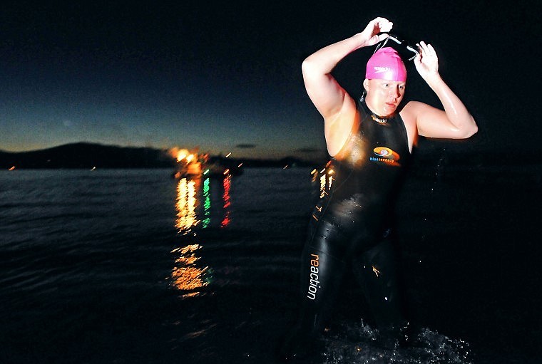 Emily Von Jentzen removes her goggles as she begins to walk onto shore at Boettcher Park in Polson after swimming across Flathead Lake Saturday evening. Von Jentzen, the first woman to swim across Flathead Lake, started her swim in Somers, completing the feat in 18 hours and 26 minutes.