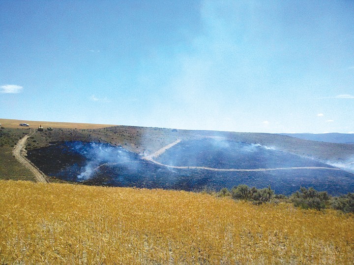 Volunteer firefighters from various points around Grant County
place their equipment and themselves between a wildfire and a wheat
field about five miles west of George, west of Interstate 90 last
Friday afternoon.