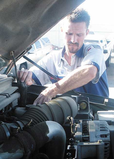 PHOTOS: 1 and 2. Discovery Ford technician John Roman recently took first place at the Discovery Ford Company/AAA Ultimate Master Technician competition.<br>3 and 4. Discovery Ford technician works on a car Friday morning. Roman recently took first place at the Discovery Ford Company/AAA Ultimate Master Technician competition.