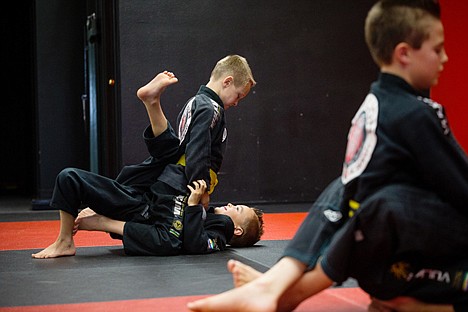 &lt;p&gt;Kyle Bridge holds Jaken Lawrence on the mat while working on jiujitsu techniques at a recent class. Ten students of Derek Cleveland's Iron Lion Jiu-Jitsu Academy will be competing in the Kids World International Brazilian Jiu-Jitsu Championship tournament without their coach.&lt;/p&gt;