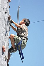 Linde Lambson, of Polson, climbs up the rock wall during the Cherry Festival last weekend in Polson.