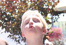 7-year-old Dyllan Hankins, of Polson, lets a cherry pit fly during the Cherry Festival last weekend in Polson.