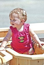 10-month-old Isabella Lund, of Ronan, checks out the cedar furniture being sold during the Cherry Festival last weekend in Polson.