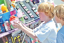 Tai Shriver, 7, and brother Noah Shriver, 6. both of Polson, look in awe at the wonder of a cherry-flavored shaved ice dish during the Cherry Festival last weekend in Polson.