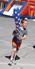 Tyler Beck, of Sumner, enjoys a prize he won from the fast-pitch booth at the Cherry Festival last weekend in Polson.