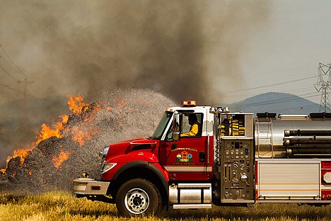&lt;p&gt;A Kootenai County Fire and Rescue firefighter sprays water on the hay stack fire with a tender truck.&lt;/p&gt;