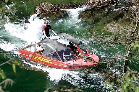 Dave Leib, patrol lieutenant for the Flathead County Sheriff's Office, scans the churning water at Devil's Elbow on the South Fork of the Flathead River Thursday morning. Leib placed a weighted bag in the water to mimic the current's effect on a swimmer. The search for Gabriel Brown who went missing last Sunday near Devil's Elbow was called off Thursday. Jennifer DeMonte photos/Daily Inter Lake