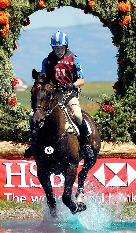 Suzy Elliott rides Chauncy through the water in the Cross Country Advanced Division.