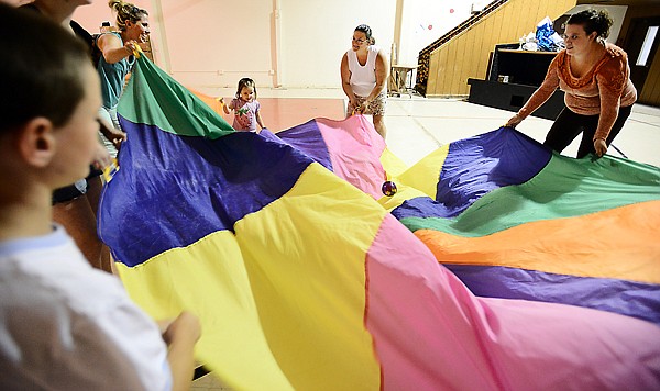 &lt;p&gt;Dana Blair, center, leads parents and kids in a game of parachute July 18 at The Gym, the Evergreen building that Family Friendly Flathead calls home. The nonprofit organization hosts a free Toddler Tyme every Thursday from 10:30 a.m. to noon at The Gym; the weekly event is a big draw for neighborhood children ages 1 to 6.&lt;/p&gt;