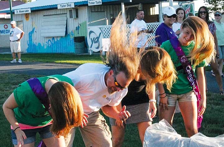 Brett Palmerton flips his hair with fellow Relay for Life participants before cutting it off for a donation to Locks of Love.