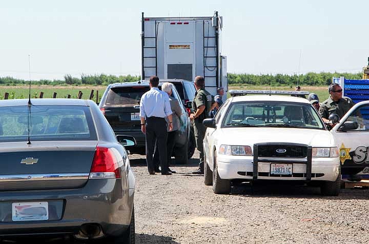 Authorities investigate the scene of the shooting Friday in a orchard near Quincy.