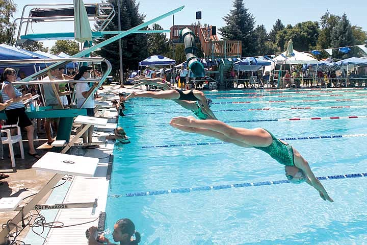 Swimmers dive off the blocks during a race at the Sizzling Summer swim meet Saturday.