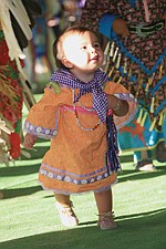 Anapo Magazu, 1, of Pablo, runs around the floor during an inter tribal dance.