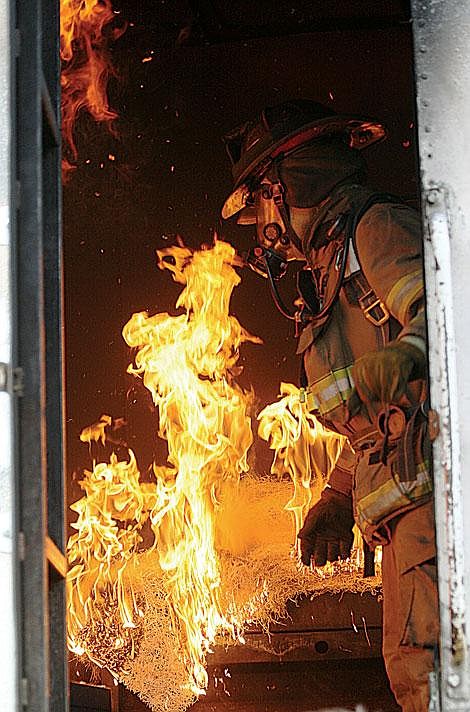 Nick Ianniello/Mineral Independent Craig Jeppson, of MSU’s Fire Services Training Center, lights fire to the burn trailer during a training exercise with the Superior Volunteer Fire Department Tuesday evening. The exercise gave volunteers a chance to deal with real flame in a safe environment.