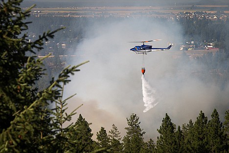 &lt;p&gt;Water is dropped from a bucket as crews help fight the wildland fire from the air.&lt;/p&gt;