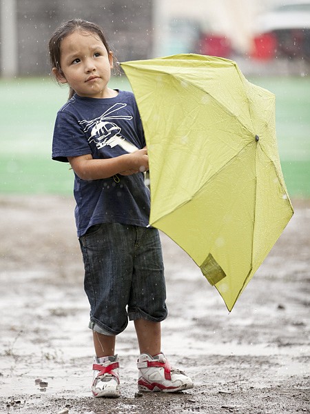 <p>Ladainian Kicking Woman, 4, waits as the rain delayed the start of the powwow on July 14 at the North American Indian Days Powwow in Browning on July 14.</p>