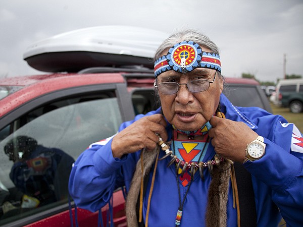 <p>After a half hour rain delay, Ray Blackwater, 72, prepares for the grand entrance at the North American Indian Days celebration in Browning on July 14. Blackwater says he asked for the rain to stop before he started to prepare for the dancing.</p>