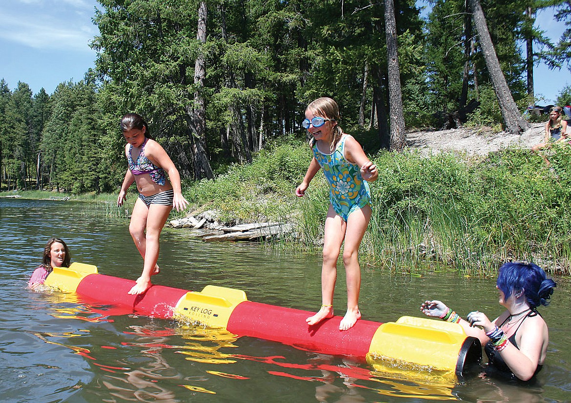 &lt;p&gt;&lt;strong&gt;4-H campers&lt;/strong&gt; Estella Stevens, left, and Brady Boll, both 9, try logrolling Wednesday at the Darrell E. Fenner 4-H Camp at Loon Lake in Bigfork while camp counselor Cassidy Norick, 14, far left and camper Sarai Lawson, 13, far right, hold onto the ends for stability. (Hilary Matheson/Daily Inter Lake)&lt;/p&gt;