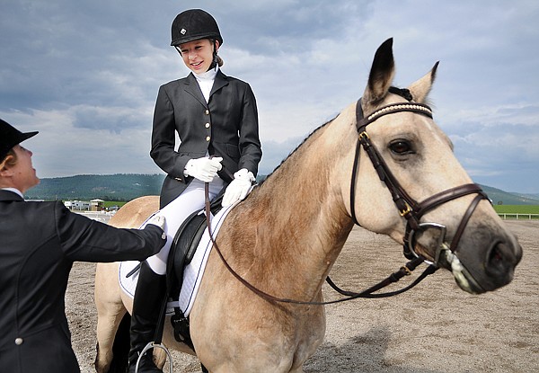 Krysta Dawson, 15, of Issaquah, Wash., gets a congratulations from her coach Katrina Bradley after completing her turn in the Open Novice Dressage competition on Thursday at The Event at Rebecca Farm.