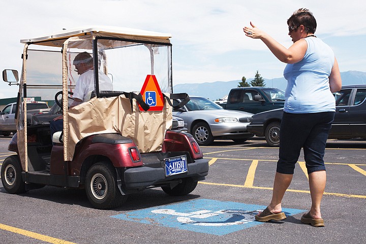 &lt;p&gt;Patrick Cote/Daily Inter Lake Examiner Rachael Mitchell checks the turn signals of Jay Barrow's golf cart in the parking lot of the Drivers License Department on Monday afternoon during his driving test for a new slow-moving vehicle license. Monday, July 16, 2012 in Kalispell, Montana.&lt;/p&gt;