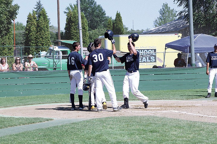 Teammates Bryton Redal (16) and Tanner Wiliams (30) greet Josh Snider at home after the left-handed sluggler belted a three-run home run to put Columbia Basin up 3-0 in the bottom of the first inning.