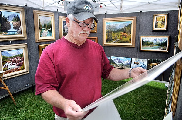 Pat Byrnes of Kalispell considers the work of Robert Marceau at the 42nd Annual Arts in the Park on Friday in Kalispell.