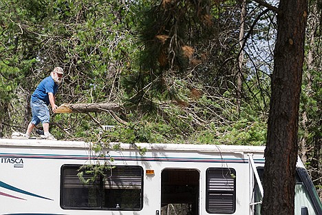 &lt;p&gt;Ernie Power, camp host at Silverwood RV Park, cleans up debris Thursday from surrounding trees that blew onto his RV after a storm fell near 100 trees and caused damage to dozens of vehicles Wednesday night.&lt;/p&gt;